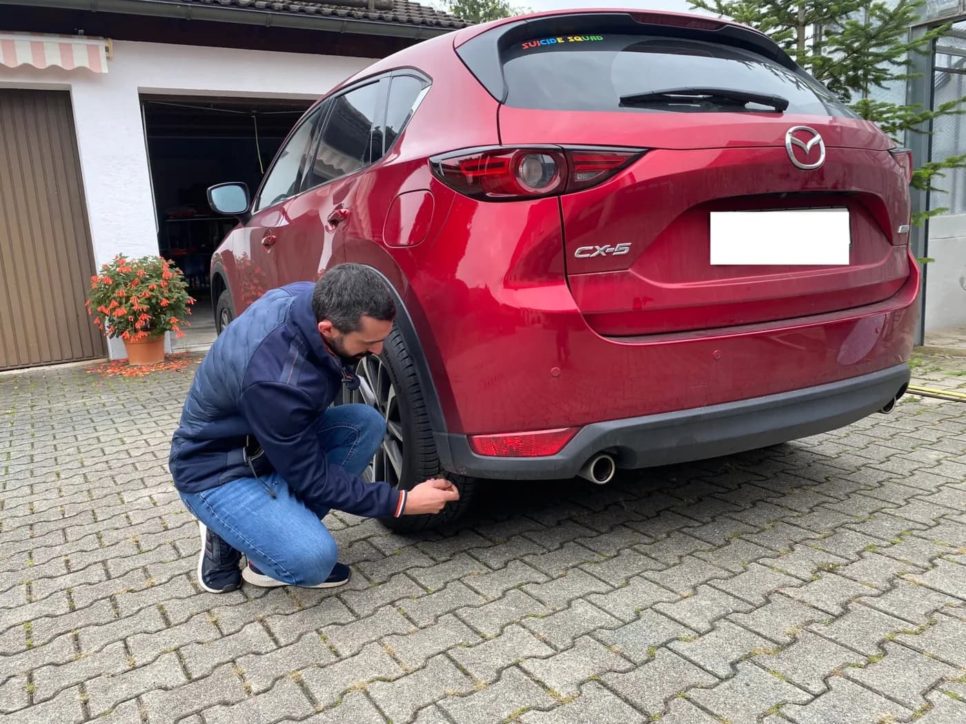 Fahrzeuguntersuchung am hinteren Kotflügel eines roten Mazda